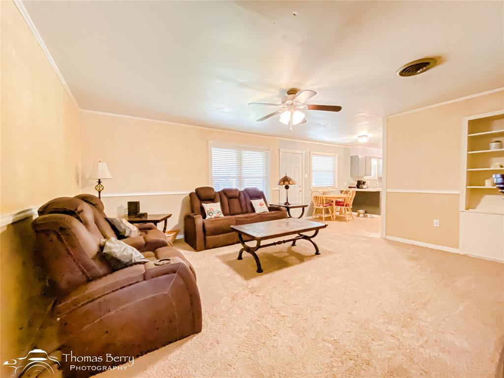1104 Hickory Street Roscoe, TX 79545 - Photo 5 of 22 a living room with furniture and a chandelier
