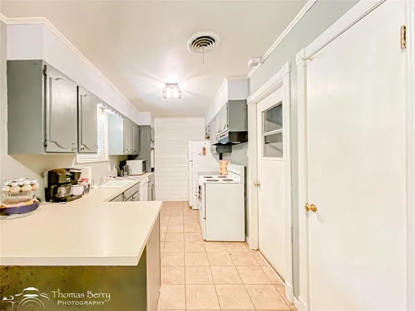 a kitchen with a sink a stove a refrigerator and cabinets