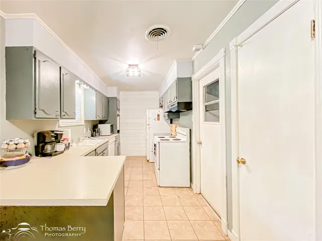 a kitchen with a sink a stove a refrigerator and cabinets