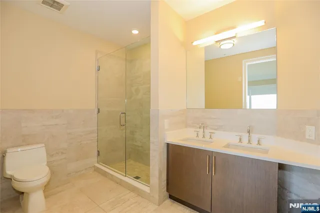 a bathroom with a shower sink vanity and toilet