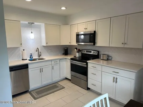 a kitchen with granite countertop a sink a stove and cabinets