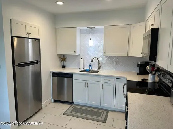 a kitchen with a refrigerator sink and cabinets