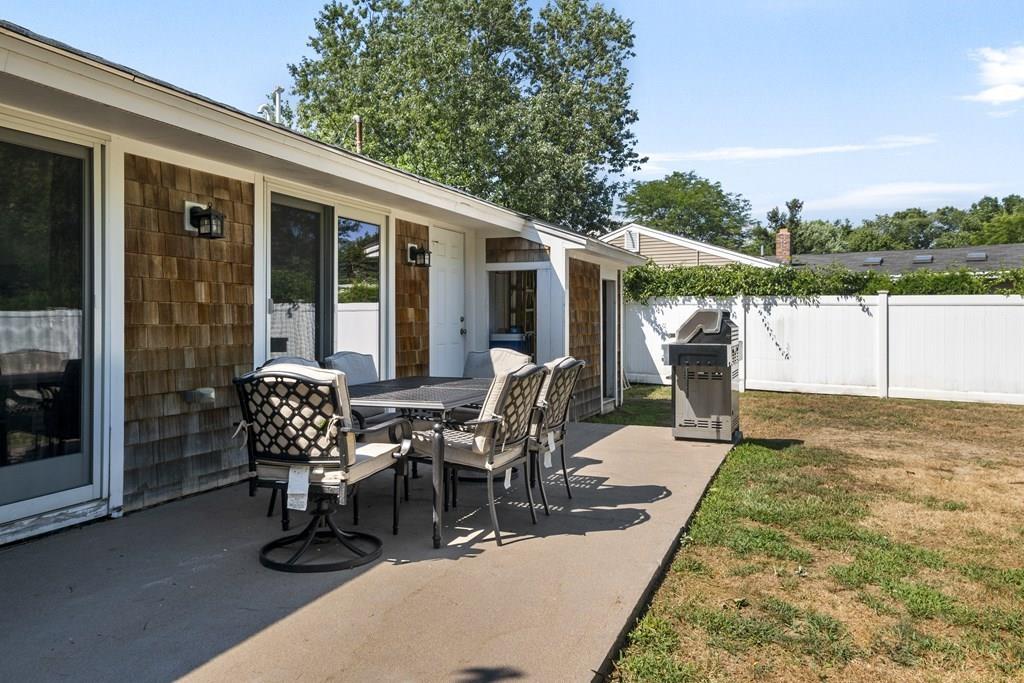 266 Bushee Road Swansea, MA 02777 - Photo 32 of 33 a view of a patio with table and chairs with wooden floor and fence