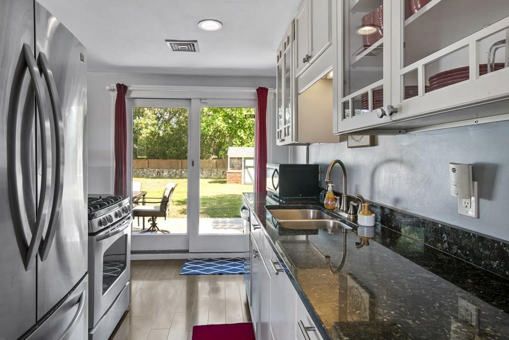 266 Bushee Road Swansea, MA 02777 - Photo 4 of 33 a kitchen with stainless steel appliances granite countertop a refrigerator a stove and a sink with wooden floor