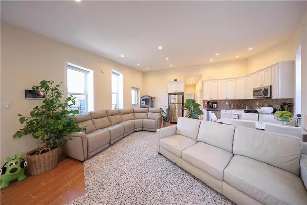 a living room with furniture kitchen view and a potted plant
