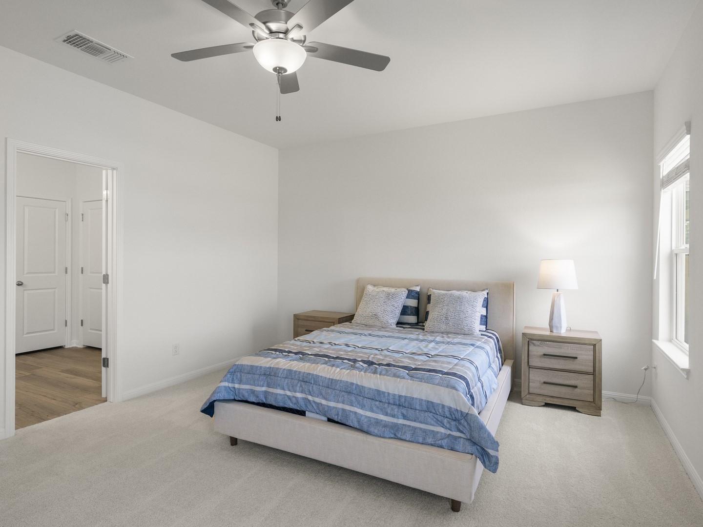 112 Mathew Street Bertram, TX 78605 - Photo 15 of 32 A well-lit bedroom provides comfortable repose with a ceiling fan for optimal airflow.