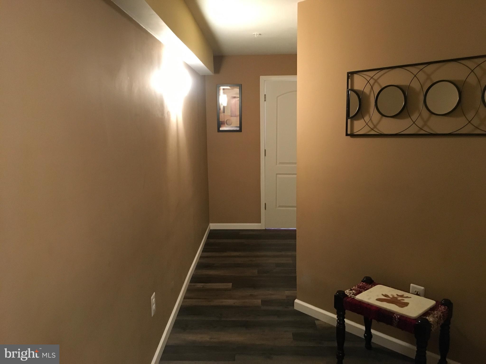 3919 Woodreed Drive Brandywine, MD 20613 - Photo 55 of 88 a view of a hallway with wooden floor and a potted plant