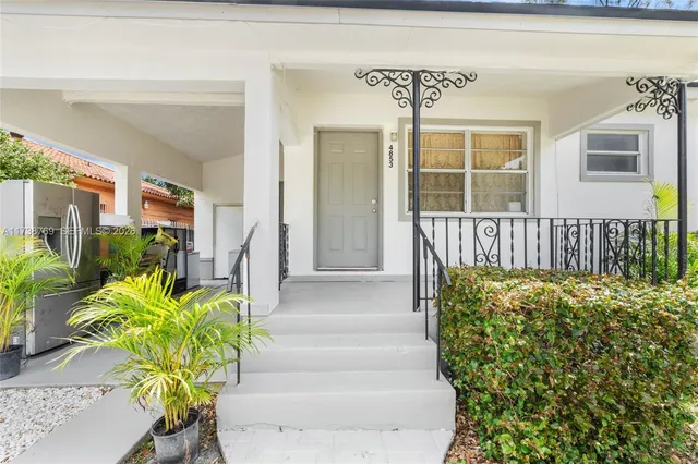 a view of front door with potted plants