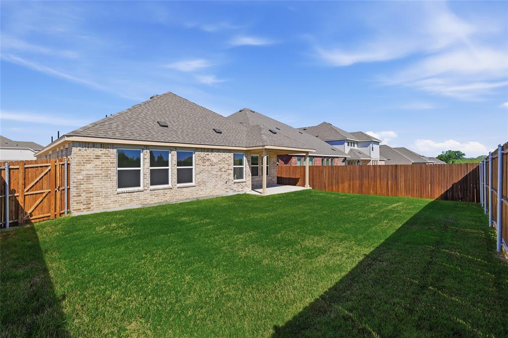 2529 Rivers W Road Anna, TX 75409 - Photo 34 of 40 Expansive backyard featuring a manicured lawn, a covered patio, new wood fencing, and a brick exterior