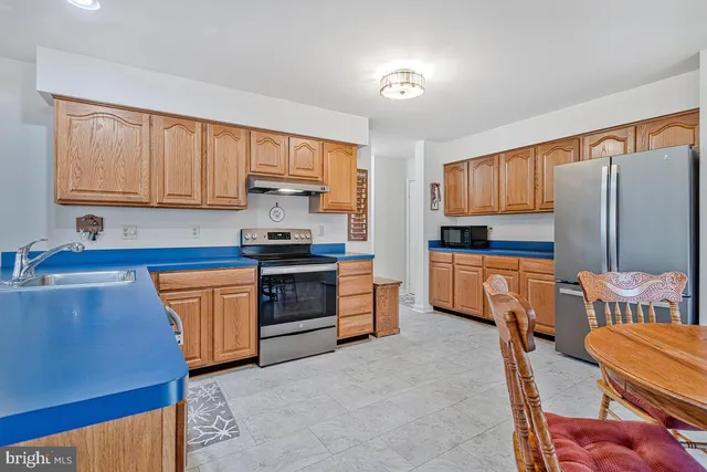 a kitchen with stainless steel appliances granite countertop a stove a sink dishwasher and a refrigerator