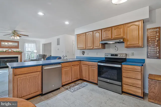 a kitchen with stainless steel appliances granite countertop a sink stove and cabinets