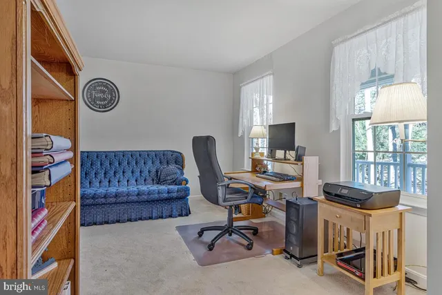 a view of a workspace with furniture and a window