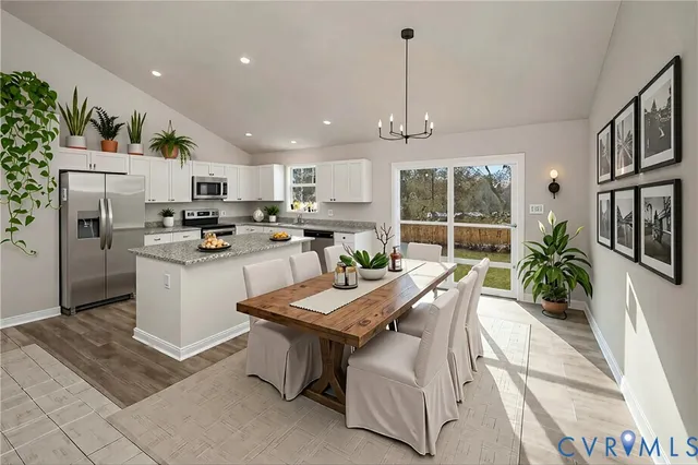 a kitchen with kitchen island a counter top space a sink stainless steel appliances and cabinets
