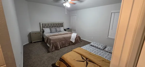 a bedroom with a bed and a ceiling fan