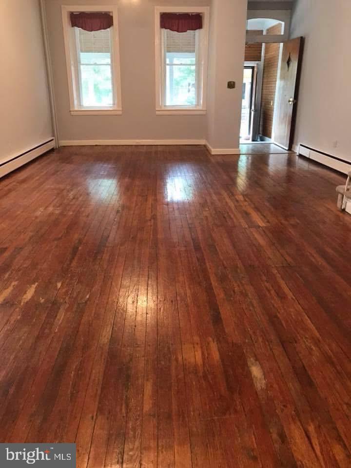 450 Seville Street Philadelphia, PA 19128 - Photo 4 of 14 an empty room with wooden floor and windows