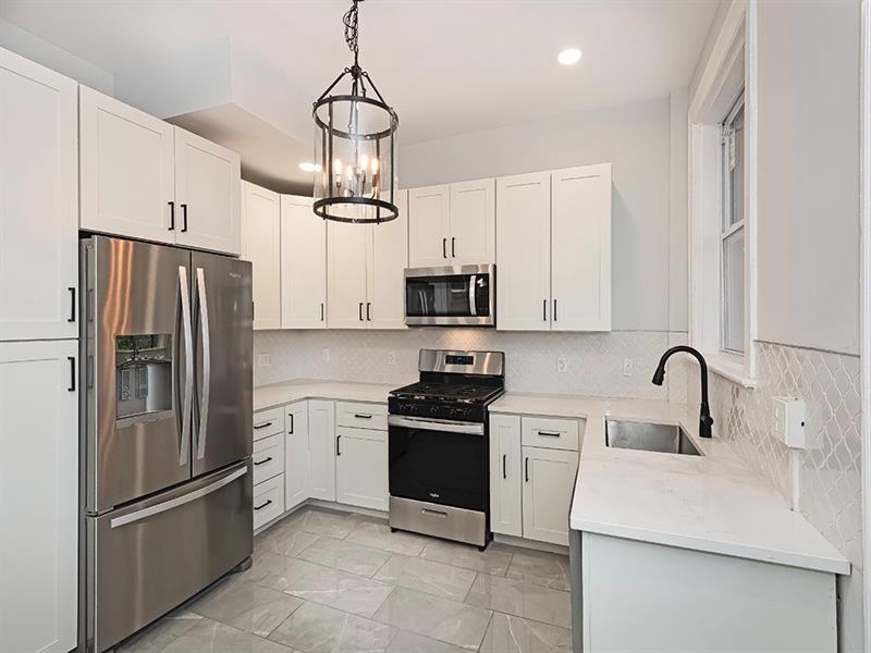 923 Adelaide Street Pittsburgh, PA 15219 - Photo 15 of 32 a kitchen with stainless steel appliances granite countertop a refrigerator a sink a stove and white cabinets