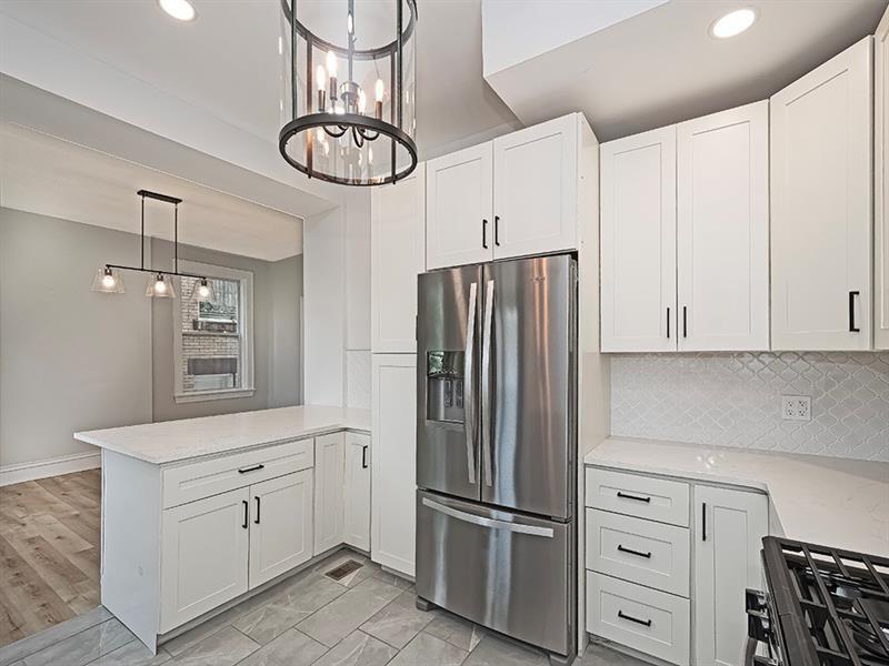 923 Adelaide Street Pittsburgh, PA 15219 - Photo 16 of 32 a kitchen with white cabinets and stainless steel appliances