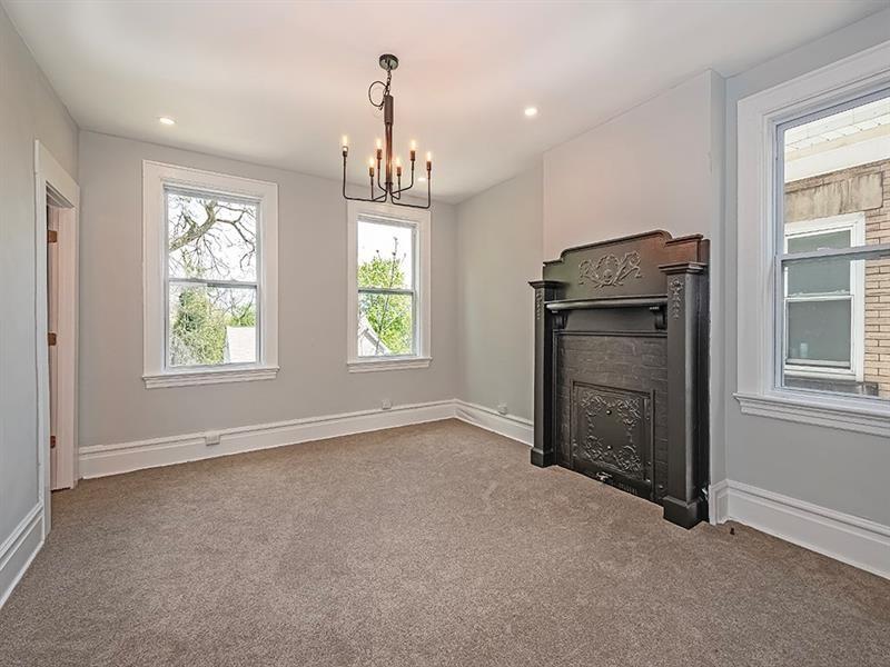 923 Adelaide Street Pittsburgh, PA 15219 - Photo 18 of 32 an empty room with windows chandelier and fireplace