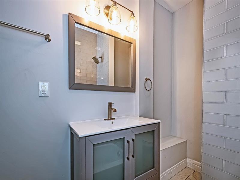 923 Adelaide Street Pittsburgh, PA 15219 - Photo 27 of 32 a bathroom with a sink and a mirror