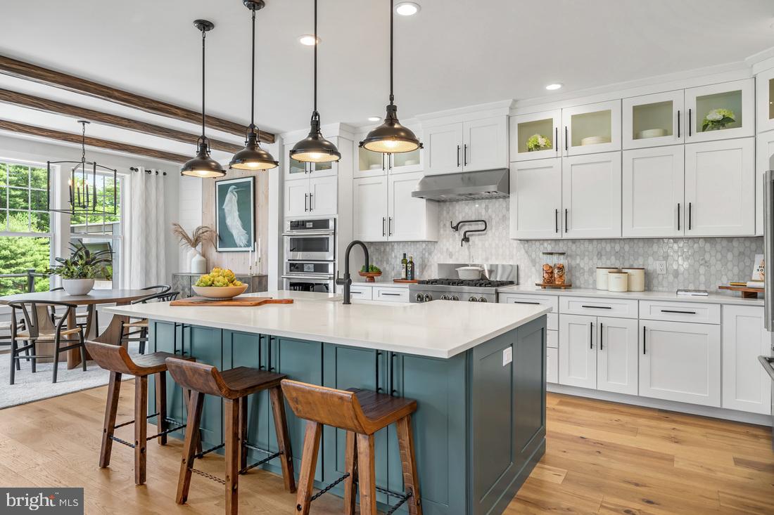229 Ezra Road Langhorne, PA 19047 - Photo 3 of 9 a kitchen with stainless steel appliances kitchen island granite countertop a table chairs and white cabinets