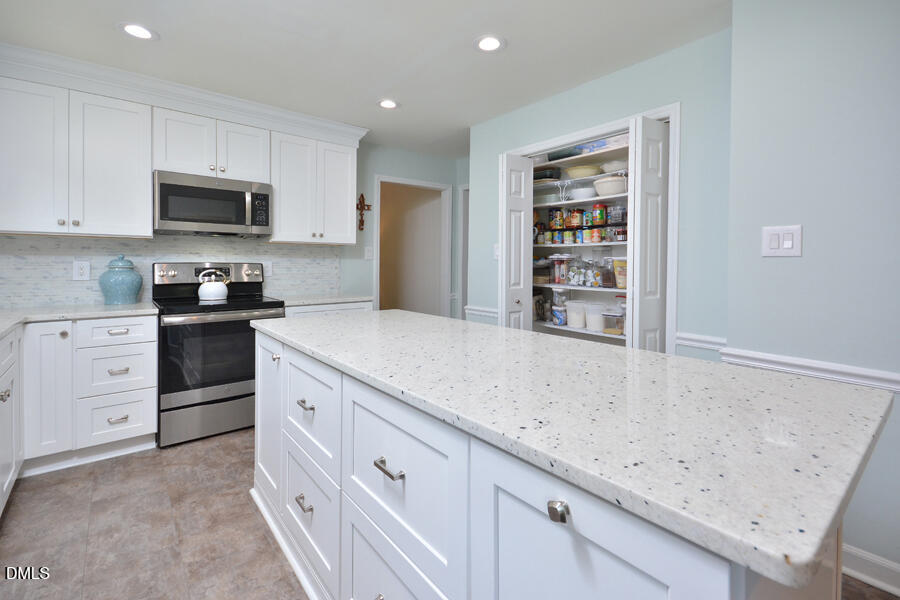313 Andover Road Durham, NC 27712 - Photo 11 of 36 a kitchen with granite countertop a sink a stove and cabinets