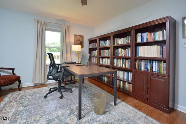 a view of a workspace with furniture and a window