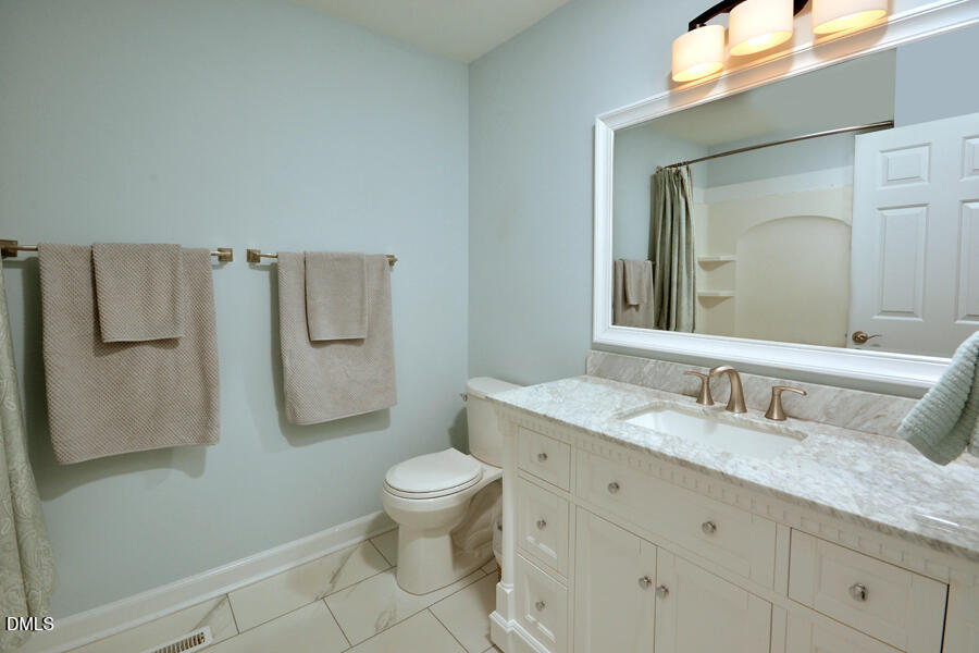 313 Andover Road Durham, NC 27712 - Photo 25 of 36 a bathroom with a granite countertop toilet sink and mirror