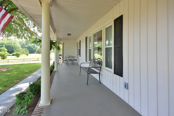 a view of a porch with furniture and garden