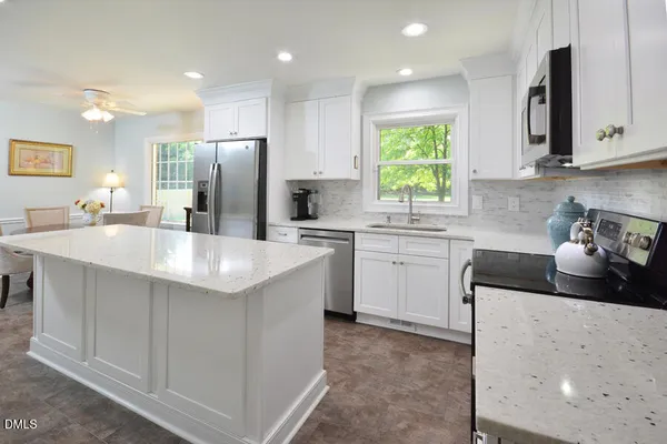 a kitchen with stainless steel appliances a sink stove and refrigerator