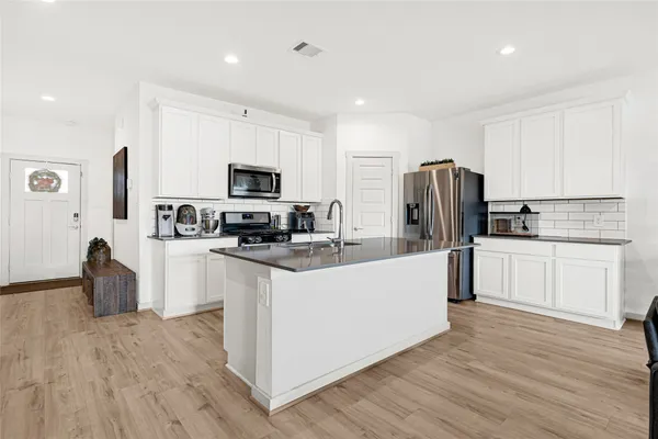 a kitchen with stainless steel appliances kitchen island granite countertop a sink and a cabinets