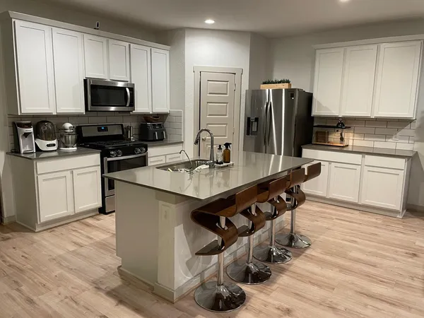 a kitchen with stainless steel appliances granite countertop a refrigerator stove microwave and sink