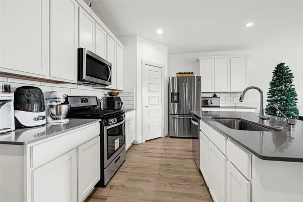 a kitchen with stainless steel appliances granite countertop a sink and a stove