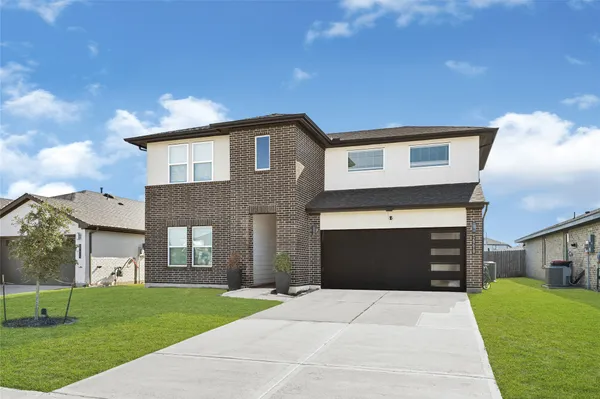 a front view of a house with a yard and garage