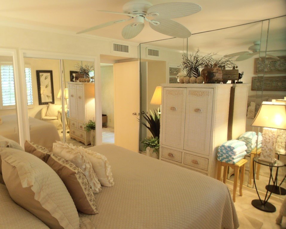 12 South Kihei Road, Unit G5 Kihei, HI 96753 - Photo 17 of 28 a bedroom with a bed a chandelier and a flat screen tv