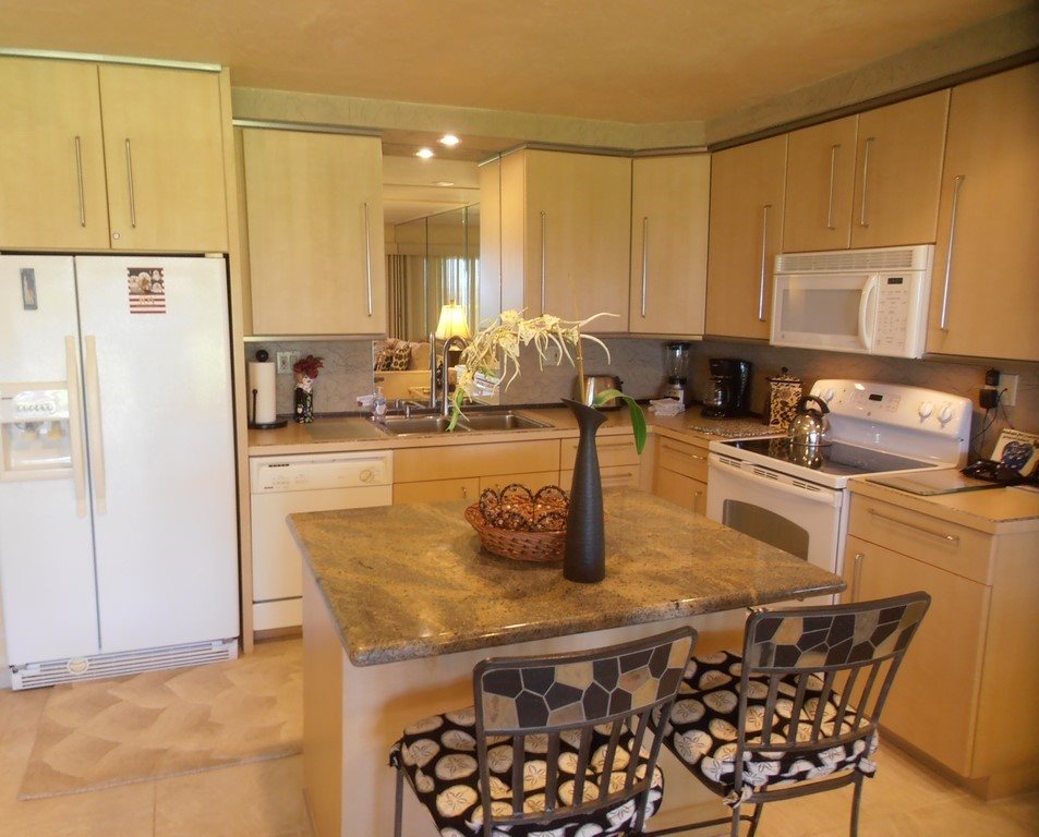 12 South Kihei Road, Unit G5 Kihei, HI 96753 - Photo 2 of 28 a kitchen with a table chairs and a refrigerator