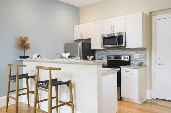a kitchen with stainless steel appliances kitchen island granite countertop a sink and cabinets