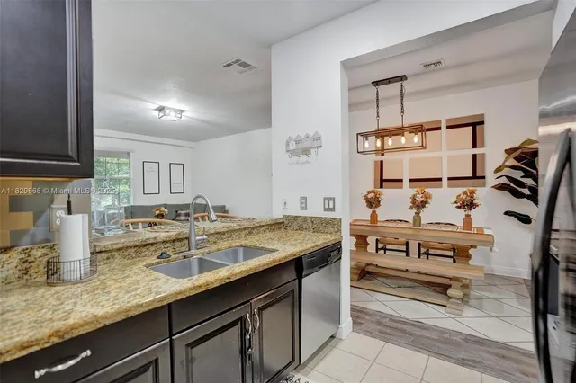 a kitchen with stainless steel appliances granite countertop a refrigerator and a stove