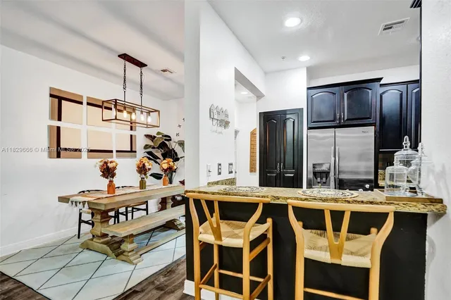 a kitchen with stainless steel appliances kitchen island granite countertop a refrigerator and a stove