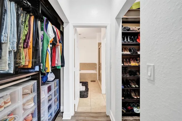 a view of walk in closet with clothes and shoes