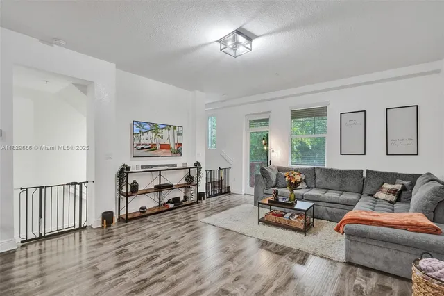 a living room with furniture and a wooden floor