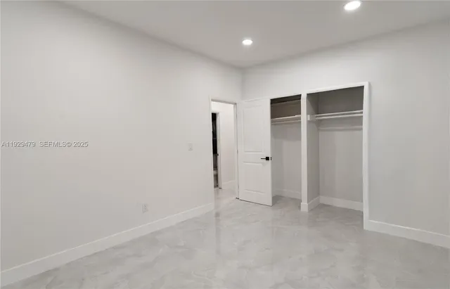 an empty room with closet and entryway