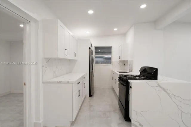 a kitchen with stainless steel appliances white cabinets and a sink