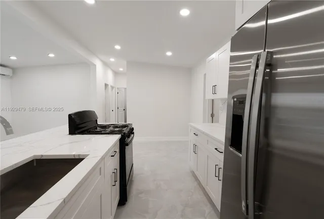 a kitchen with stainless steel appliances a sink stove and refrigerator