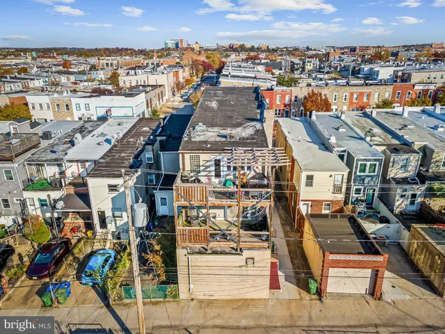 an aerial view of a city with lots of residential buildings and ocean view in back