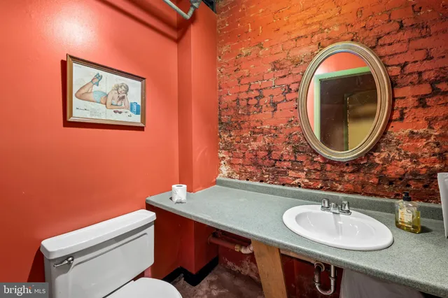 a bathroom with a toilet a sink and a mirror