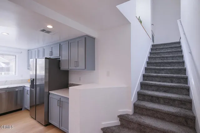 a view of a kitchen with refrigerator and cabinets