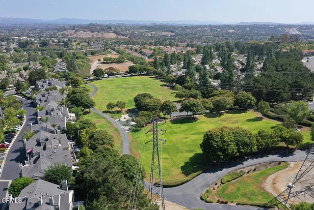 an aerial view of a houses with a yard and lake view