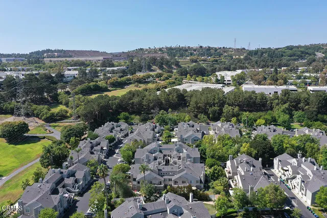 an aerial view of a city with lots of residential buildings and mountain view in back