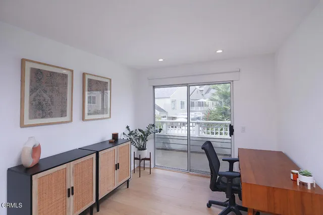 a view of a workspace with furniture and a window