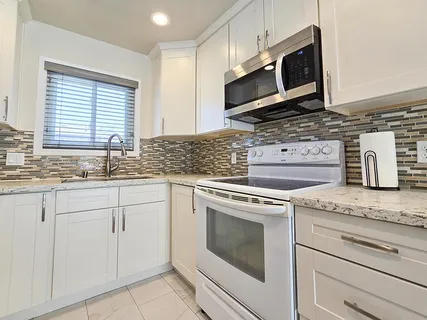 a kitchen with granite countertop cabinets stainless steel appliances and a sink